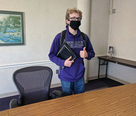 masked student standing in study room